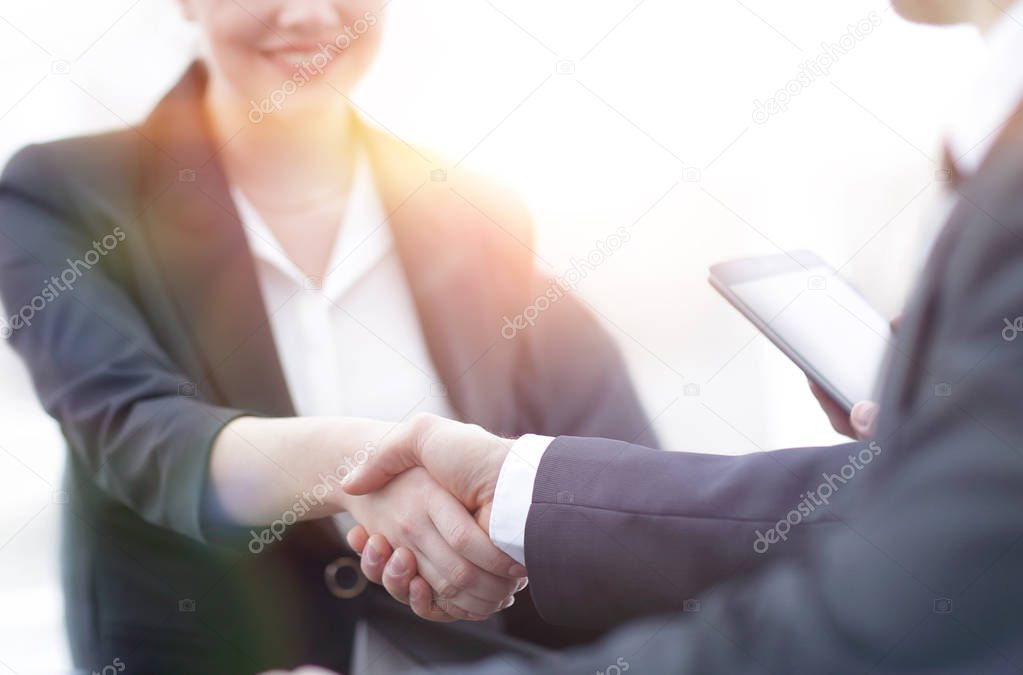 closeup of business woman shaking hands with her colleague.