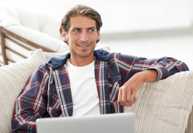 dizüstü bilgisayarda çalışan ve kameraya bakarak başarılı adam. Yukarıdan görüntülemek