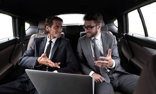 Два бизнесмена разговаривают, сидя в машине — стоковое фото
