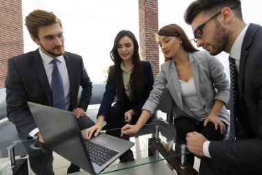 Yoğun iş adamları bir konferans sırasında bir dizüstü bilgisayarı kullanıyor