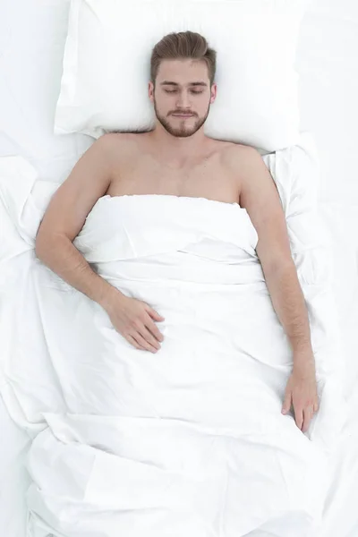 Hombre joven relajación en la cama vista superior — Foto de Stock