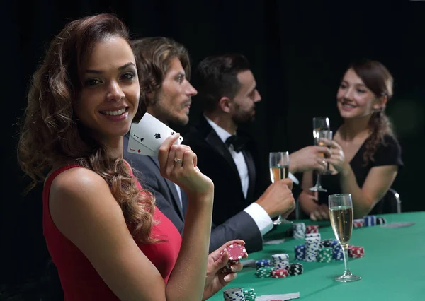 Young brunette woman playing poker on black background — Stock Photo, Image