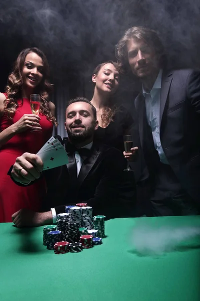 Porträtt av grupp människor med drycker som spelar poker på casino — Stockfoto