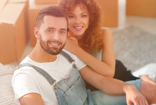 Jovem casal sentado no chão em um novo apartamento — Fotografia de Stock