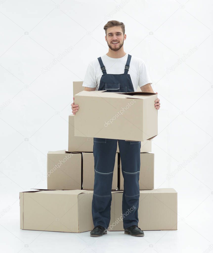 Young man carrying a box to the pile of boxes.