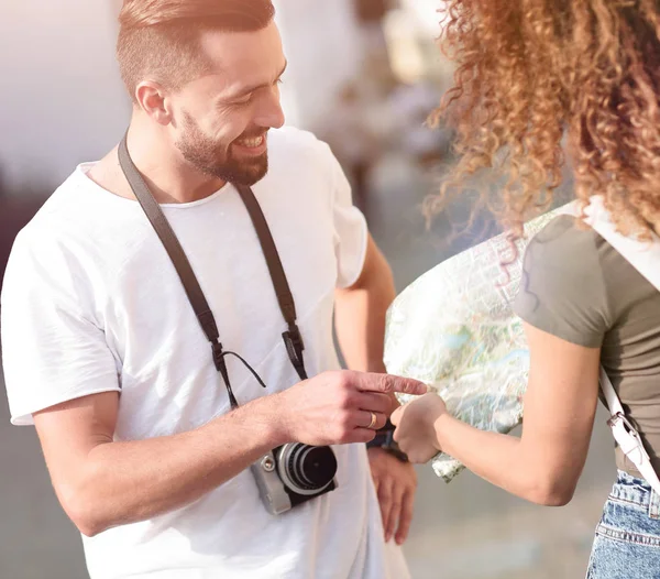 Genç çift mutlu görünürken bir rehbere bakıyor.