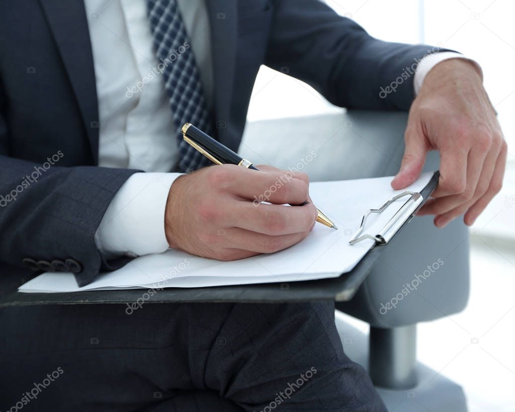 Businessman signs a contract. Holding pen in hand.