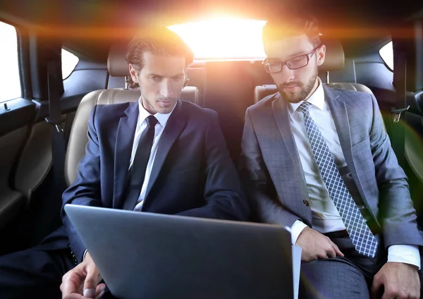 Obchodní partneři sedí v luxusních aut — Stock fotografie