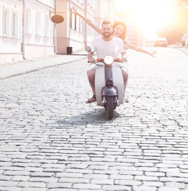 mutlu genç bir çift bir scooter üzerinde eğleniyor