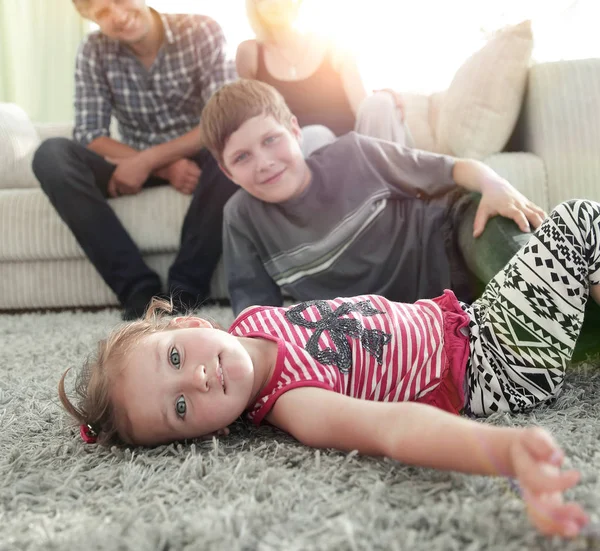 Ritratto di bambini mentre i genitori si siedono sul divano in salotto — Foto Stock