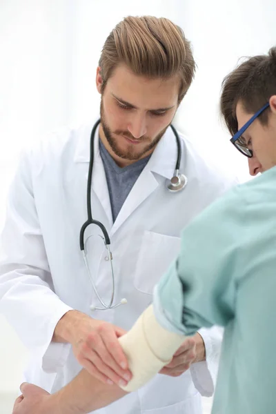 Ortopedista aplicando vendaje en el brazo de los pacientes — Foto de Stock