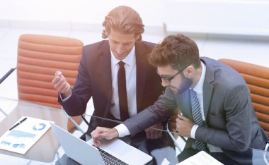 dizüstü bilgisayarda çalışan iki iş adamı