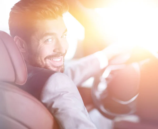 Hombre de éxito sentado al volante de un coche de prestigio — Foto de Stock