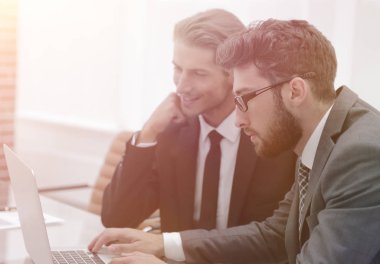 dizüstü bilgisayar ekranına bakarak iş ortakları.