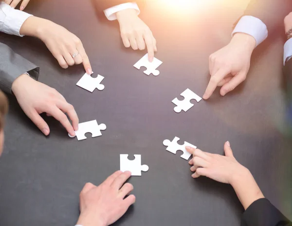 Puzzelstukjes in handen van het bedrijf-team — Stockfoto