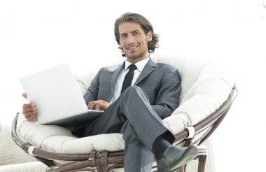 şık rahat sandalyede oturan bir dizüstü bilgisayar ile modern iş adamı