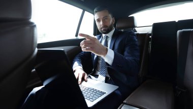 parmağını ileriye dönük ve arabanın arka koltukta oturan işadamı