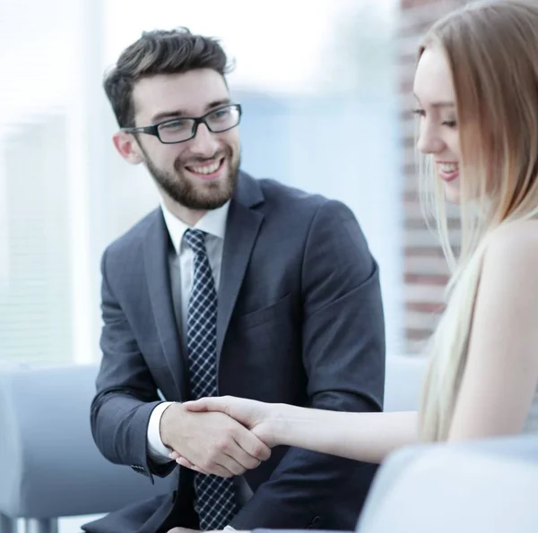 Primer plano de un gerente le da la mano a un cliente regular . — Foto de Stock