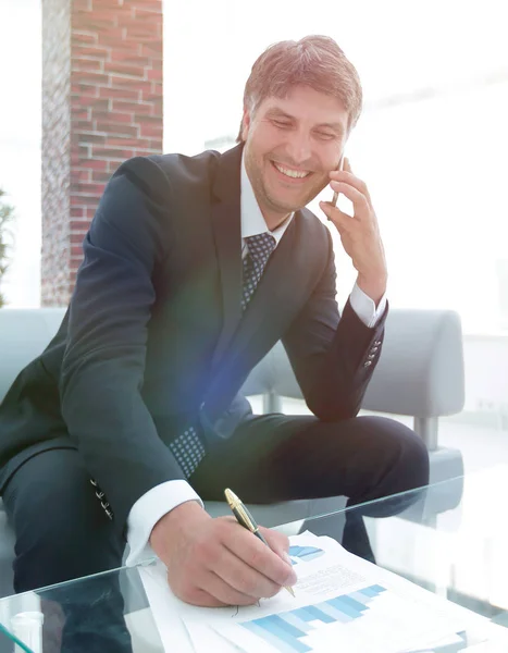 Uomo d'affari con uno smartphone sul posto di lavoro — Foto Stock