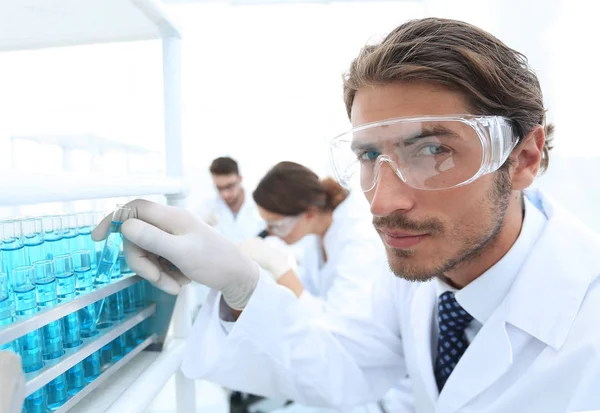 Mannen i glasögon att kontrollera vätska in vitro-. — Stockfoto