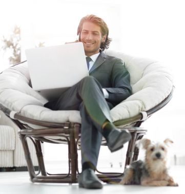 bir dizüstü bilgisayarda çalışan ve bir sma üzerinde konuşurken başarılı iş adamı