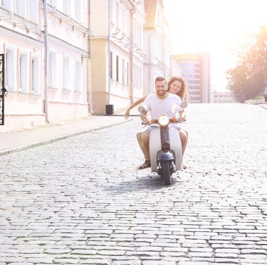 mutlu genç bir çift bir scooter üzerinde eğleniyor