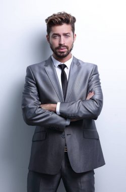 Çapraz kollarla poz veren genç iş adamı.