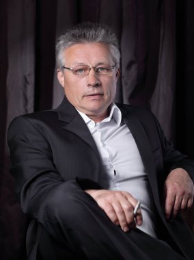 bir sandalyede oturan bir sigara ile üst düzey iş adamı