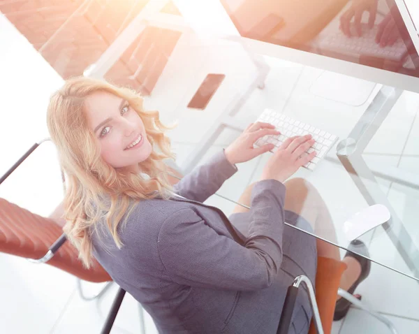 Business woman sitting at her Desk and looking at camera — Stock Photo, Image
