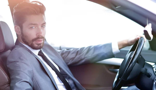 Handsome businessman in the drivers seat in his car — Stock Photo, Image