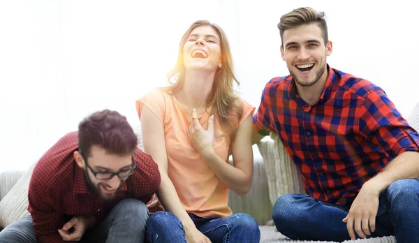 Grupp unga människor som skrattar och sitter i soffan — Stockfoto