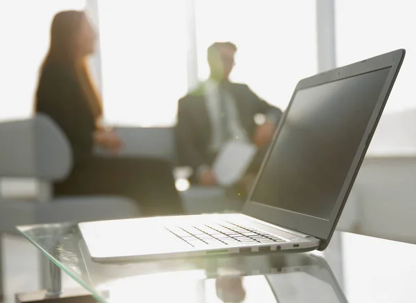 Concéntrate en el portátil sobre la mesa. Personas borrosas en el fondo . —  Fotos de Stock