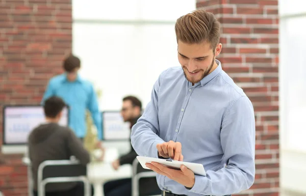 Bonito empresário usando um tablet no escritório . — Fotografia de Stock