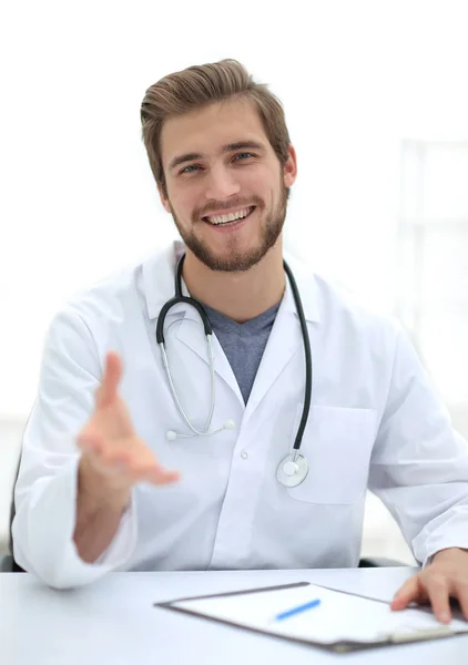 Bonito médico de casaco branco está oferecendo sua mão — Fotografia de Stock