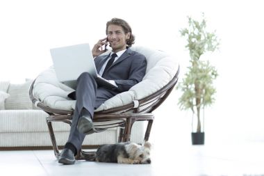 oturma odasında bir smartphone cep telefonu ile konuşurken iş adamı