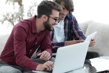 İki web tasarımcıları bir proje bir dizüstü bilgisayar önünde tartışmaya portresi