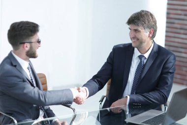 İş adamları el sıkışır, masada otururlar. .