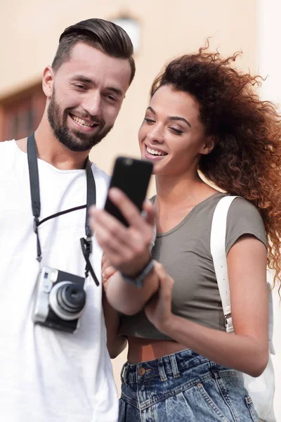 Feliz jovem casal em busca de localização tanto no telefone móvel — Fotografia de Stock