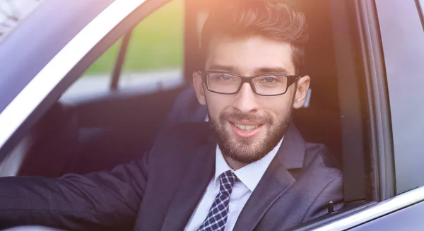 Uomo d'affari in giacca e cravatta guida la sua auto di lusso . — Foto Stock