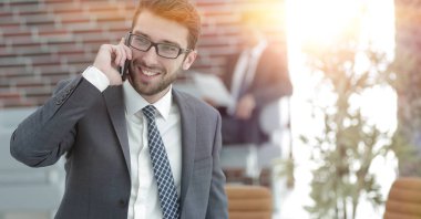 ofisinde smartphone cep telefonu ile konuşurken işadamı