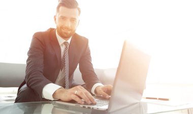 Modern ofis dizüstü bilgisayarda çalışan başarılı erkeğin