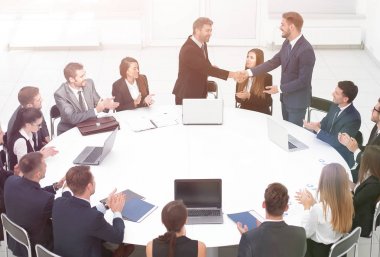 iş ortakları yuvarlak masa yakınındaki müzakerelerinde el sallamak