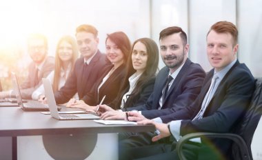 İş ekibi konferans odasındaki masada oturuyor.