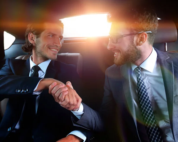 Handshake obchodních partnerů sedí v autě — Stock fotografie