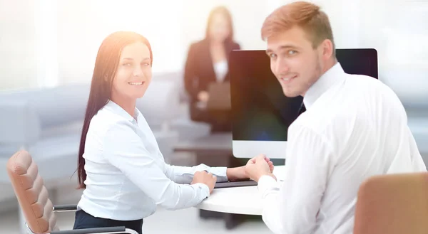 Leden van het business team zitten aan de balie en kijken naar de camera . — Stockfoto