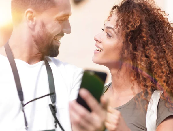 Leende par använda smart telefon tillsammans i city — Stockfoto