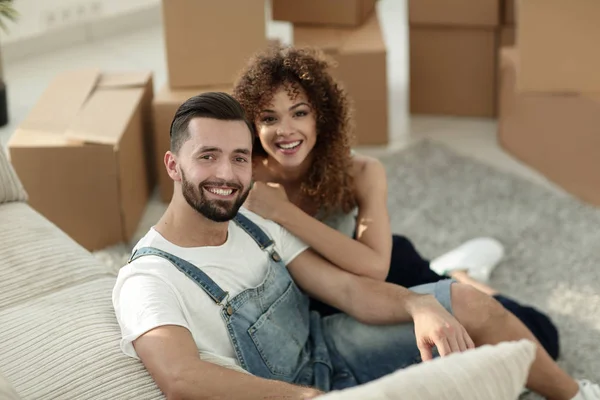 Jovem casal sentado no chão em um novo apartamento — Fotografia de Stock