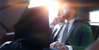 İşadamı dizüstü bilgisayarla çalışıyor ve pencereden dışarı bakıyor. 