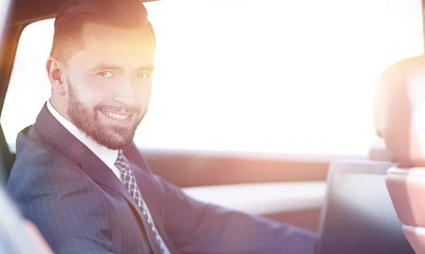 Close-up of a businessman with a laptop sitting in the car — Stock Photo, Image