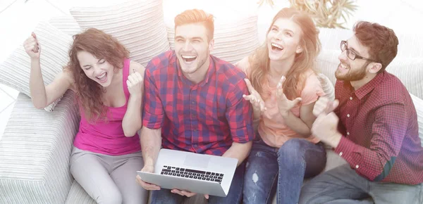 Grupo de amigos viendo un vídeo en un ordenador portátil y riendo — Foto de Stock